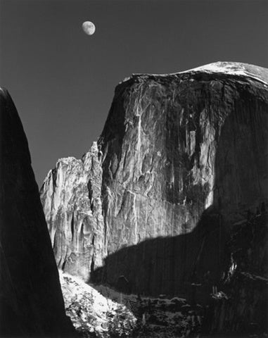 a black and white photo of a person on a rock 
